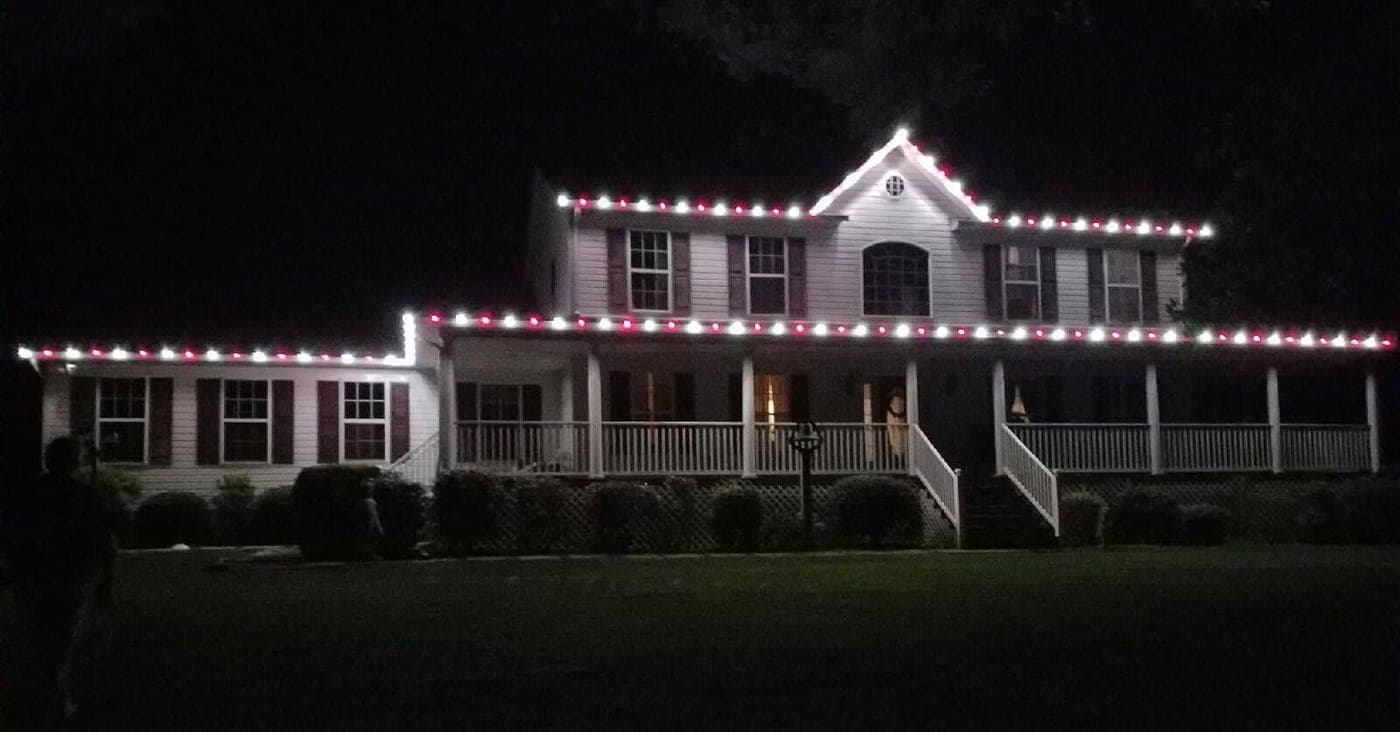 Red and white roofline Christmas lights on a two-story home in La Plata, MD